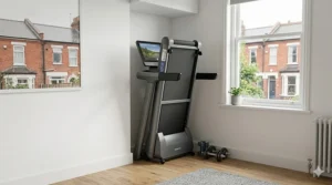 A compact, folding smart treadmill stored neatly in a typical UK terraced house spare room.