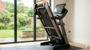 The NordicTrack Commercial 1750 treadmill folded vertically using the SpaceSaver design for storage in a compact room.