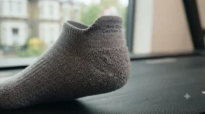 A magnified view of the grey running sock, focusing on the reinforced, cushioned heel tab specifically designed for blister protection.