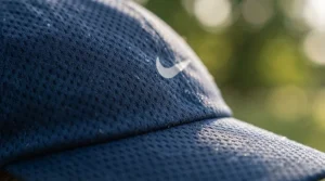 Flat lay of summer running gear featuring a protective running hat, sunglasses, and running bottle.