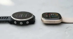 Side-by-side comparison of a Garmin running watch and a Fitbit smartwatch casing, showing screen size and build quality.