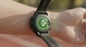 Close-up of optical heart rate sensor lights flashing on the back of a Garmin watch worn on a runner's wrist.