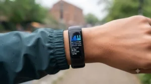 Macro photograph of the black fitness tracker screen, displaying a detailed sleep analysis chart showing Deep, Light, and REM sleep, along with the text 'TOTAL SLEEP: 8h 30m' and 'SLEEP SCORE: 92/100'. The wrist and dark teal jacket cuff from previous images are visible, maintaining the natural lighting.
