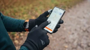 Runner using a smartphone while wearing cheap touchscreen-friendly running gloves outdoors.