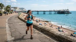 Jogger deciding on bone conduction vs wireless earbuds for running along the Brighton seafront
